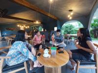Un grupo de personas sentadas alrededor de una mesa en un restaurante. en La Collina Villa, en Jepara
