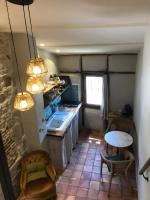 a kitchen with a counter and a table in a room at Le pigeonnier du beffroi in Bruniquel