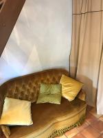 a brown couch with yellow pillows on it at Le pigeonnier du beffroi in Bruniquel
