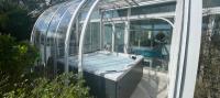 a glass house with a swimming pool in it at Hôtel Arcadia in Lannion