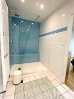 a bathroom with a shower with blue tiles at Le Georges V in Alzonne