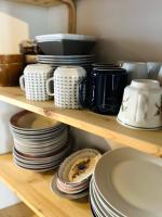 a shelf with plates and cups and dishes on it at Le Georges V in Alzonne