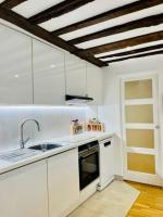 - une cuisine avec des placards blancs et un évier dans l&#39;établissement ENJOY PARIS, à Paris