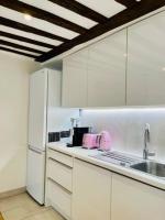 une cuisine avec des armoires blanches et un appareil rose dans l&#39;établissement ENJOY PARIS, à Paris