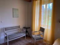 two chairs and a table in a room with a window at La maison du pech in Monteils