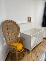 a wicker chair sitting next to a crib at Superbe appartement F4 au cœur de Malo-les-bains in Dunkerque