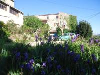 a garden with purple flowers in front of a building at La Colline Bleue in Banne