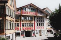 un edificio de color rosa y blanco en Traube Restaurant &amp; Hotel, en Appenzell