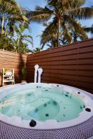 a jacuzzi tub on a patio with palm trees at Taj Holiday Village Resort & Spa, Goa in Candolim