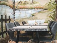 a table with chairs and a painting of a river at Modern holiday home in Bazel with garden in Bazel