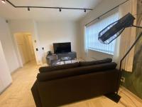 a living room with a couch and a television at Modern holiday home in Bazel with garden in Bazel