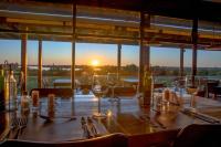 een tafel met wijnglazen en servetten en een zonsondergang bij Midland Hotel & Resort All Inclusive in Paso de los Toros