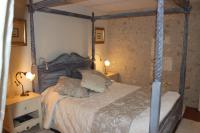 a bedroom with a canopy bed with two pillows at Moulin De Larcy in Ribérac