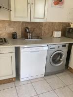 a kitchen with a washing machine under a counter at Gites de Lyse avec Jacuzzi in Roujan