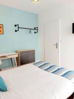 a bedroom with a white bed with a blue and white stripes at Lumineux T5 en centre ville in Angoulême