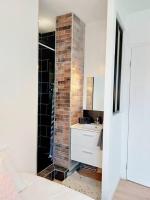 a bathroom with a brick wall and a sink at Lumineux T5 en centre ville in Angoulême