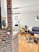 a living room with a brick wall and a couch at Lumineux T5 en centre ville in Angoulême