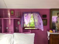 a pink bedroom with a window and a purple wall at Azienda agricola Della Mezzaluna in Stiava