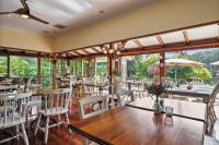 een restaurant met tafels, stoelen en ramen bij Forest Lodge Resort in Pemberton
