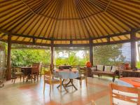 una sala da pranzo con tavolo e sedie in un padiglione di Cabé Bali a Jasri