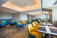 Un restaurante con sillas y mesas amarillas y azules. en Starlit sky Hotel - Shenzhen Luohu Baoneng Center Branch, en Shenzhen