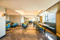 Un restaurante con sillas y mesas amarillas y azules. en Starlit sky Hotel - Shenzhen Luohu Baoneng Center Branch, en Shenzhen