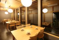 un ristorante con tavoli e sedie in legno e luci di yabenomori a Miyanoo