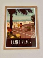 a framed poster of a beach with two people walking at Studio côté plage tout équipé vue sur le Canigou in Canet-en-Roussillon