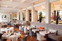 um restaurante com mesas, cadeiras e um bar em Paris Marriott Charles de Gaulle Airport Hotel em Roissy-en-France