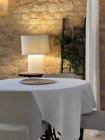 カルサック・アイヤックにあるHôtel La Villa Romaineの白いテーブル(椅子、ランプ付)