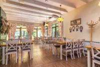 een eetkamer met houten tafels en stoelen bij Osada Grzybowski Młyn apartamenty z dużym ogrodem KAISERÓWKA in Grzybowo