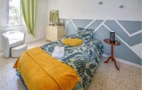 a bedroom with a bed and a chair and a table at Amazing Home In Lapalud With Outdoor Swimming Pool, Wifi And Private Swimming Pool in Lapalud