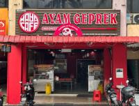 um restaurante com uma placa vermelha e motocicletas estacionadas do lado de fora em Sabai Sabai Guesthouse in Bayan Lepas em Bayan Lepas