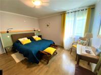 a bedroom with a large blue bed with yellow pillows at CHAMBRES D&#39;HOTES 2 à 4p ou GITE DE GROUPE 15p, 7 ch, 6 sdb, parc et salle de réception in Villeneuve-de-Berg