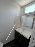 ein weißes Badezimmer mit einem Waschbecken und einem Spiegel in der Unterkunft studio trankil coeur d&#39;Ancenis - balcons d&#39;Ancenis in Ancenis