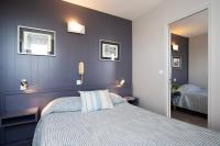 a bedroom with a bed with a blue wall at Hotel La Chope in Cambrai