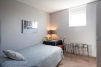 a bedroom with a bed and a desk and a window at Hotel La Chope in Cambrai