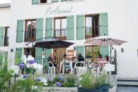 Un grupo de personas sentadas en una mesa con sombrillas. en L’AZIMUT, en Senez