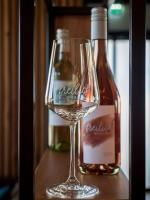 a glass of wine next to a bottle of alcohol at freilich ESSEN TRINKEN SCHLAFEN digitaler self check in in Laa an der Thaya