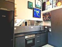 a kitchen with black counters and a stove top oven at Studio mezzanine entier à 5min de la plage et de St tropez in Cogolin