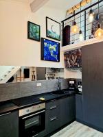 a kitchen with black cabinets and a stove top oven at Studio mezzanine entier à 5min de la plage et de St tropez in Cogolin