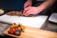 a person is cutting food on a cutting board at ANC Resort in Caloura