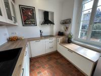 a kitchen with white cabinets and a tile floor at Appartement familial idéalement situé in Cauro