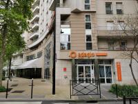 un bâtiment avec un panneau orange sur son côté dans l&#39;établissement Appart Hotel La Defense, à Courbevoie