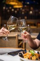 スキアトスタウンにあるSkiathos Theros, Philian Hotels and Resortsの白ワインを持っている