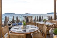 スキアトスタウンにあるSkiathos Theros, Philian Hotels and Resortsの海とテーブルと椅子が備わるレストラン