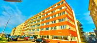 a large orange building with cars parked in a parking lot at Hotel de l&#39;Europe in Dieppe