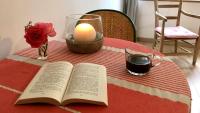 an open book on a table with a candle and roses at Maison d hôtes Casa Sana in Pillac