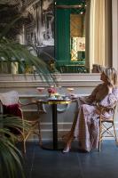 two women sitting in chairs in a room with a table at Maalot Roma - Small Luxury Hotels of the World in Rome