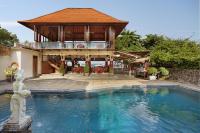 una piscina frente a una casa con un edificio en Respati Beach Hotel, en Sanur